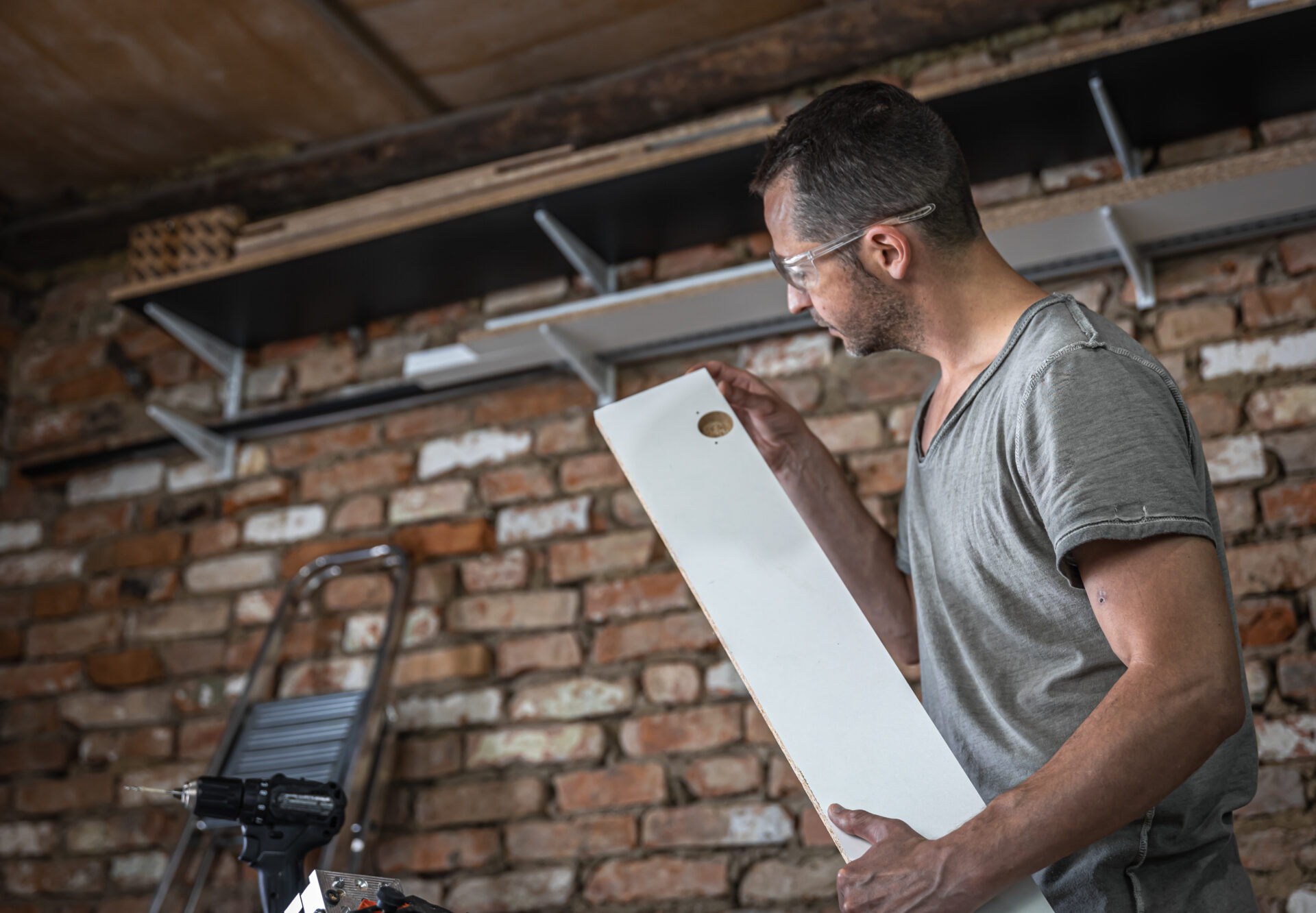 The carpenter evaluates the drilling result in the board